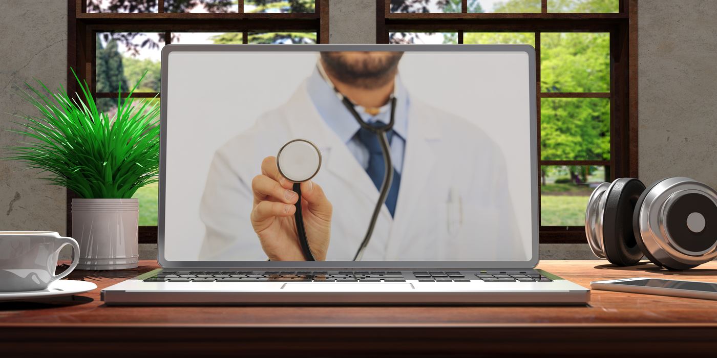 A doctor on a laptop video call holding up a stethoscope